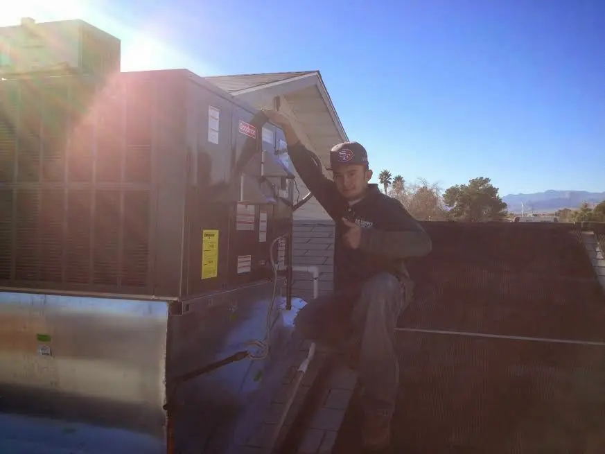 HVAC technician performing Air Duct Repair on a rooftop unit in Eureka